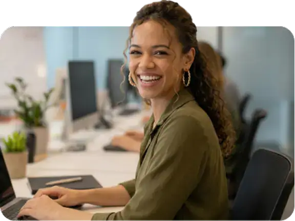 Freundliche Frau arbeitet an einem Computer im Büro.