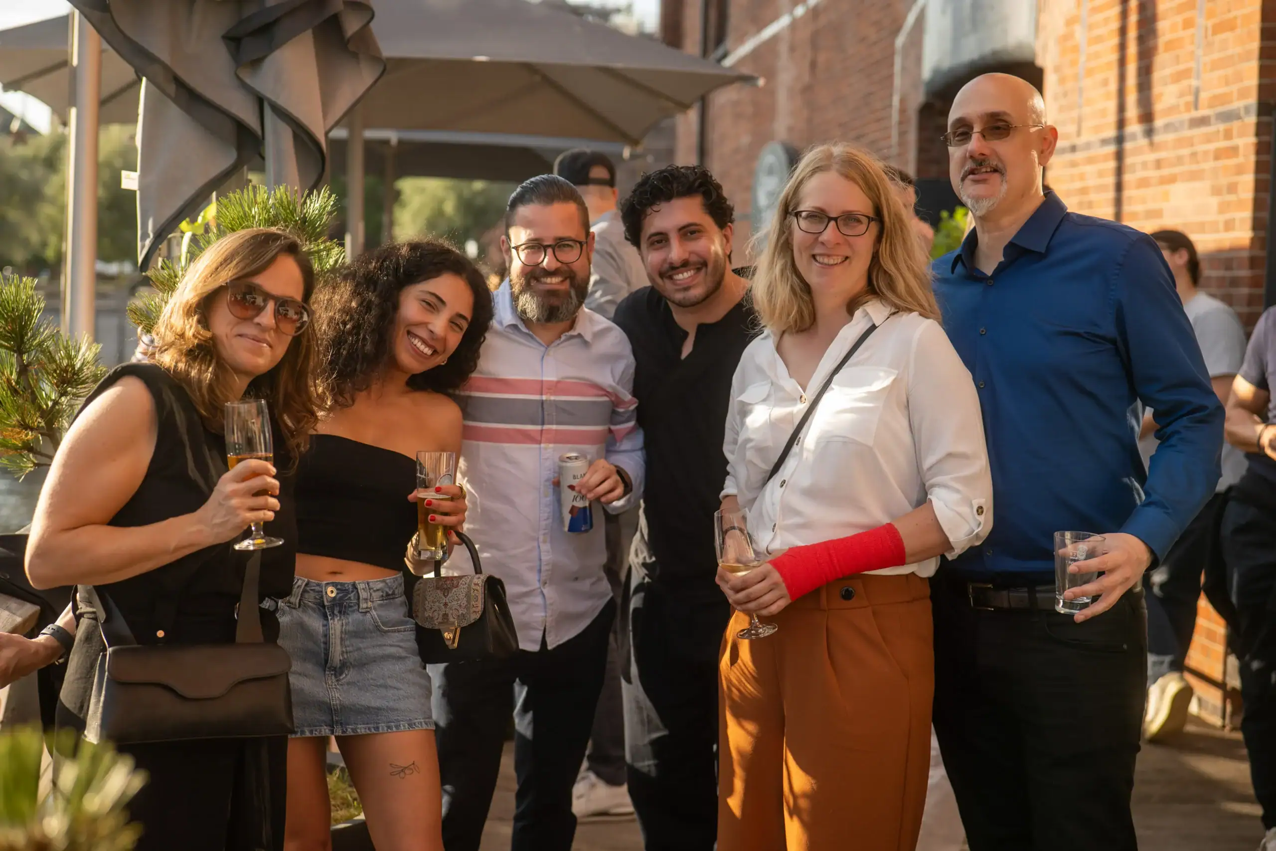 Menschen beim geselligen Treffen im Freien, lachen und trinken zusammen.