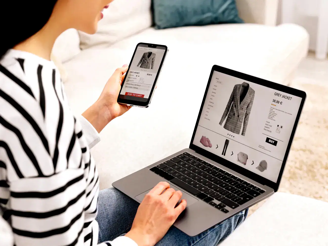 Hochwertiger grauer Mantel auf Laptop und Smartphone im Online-Shop.