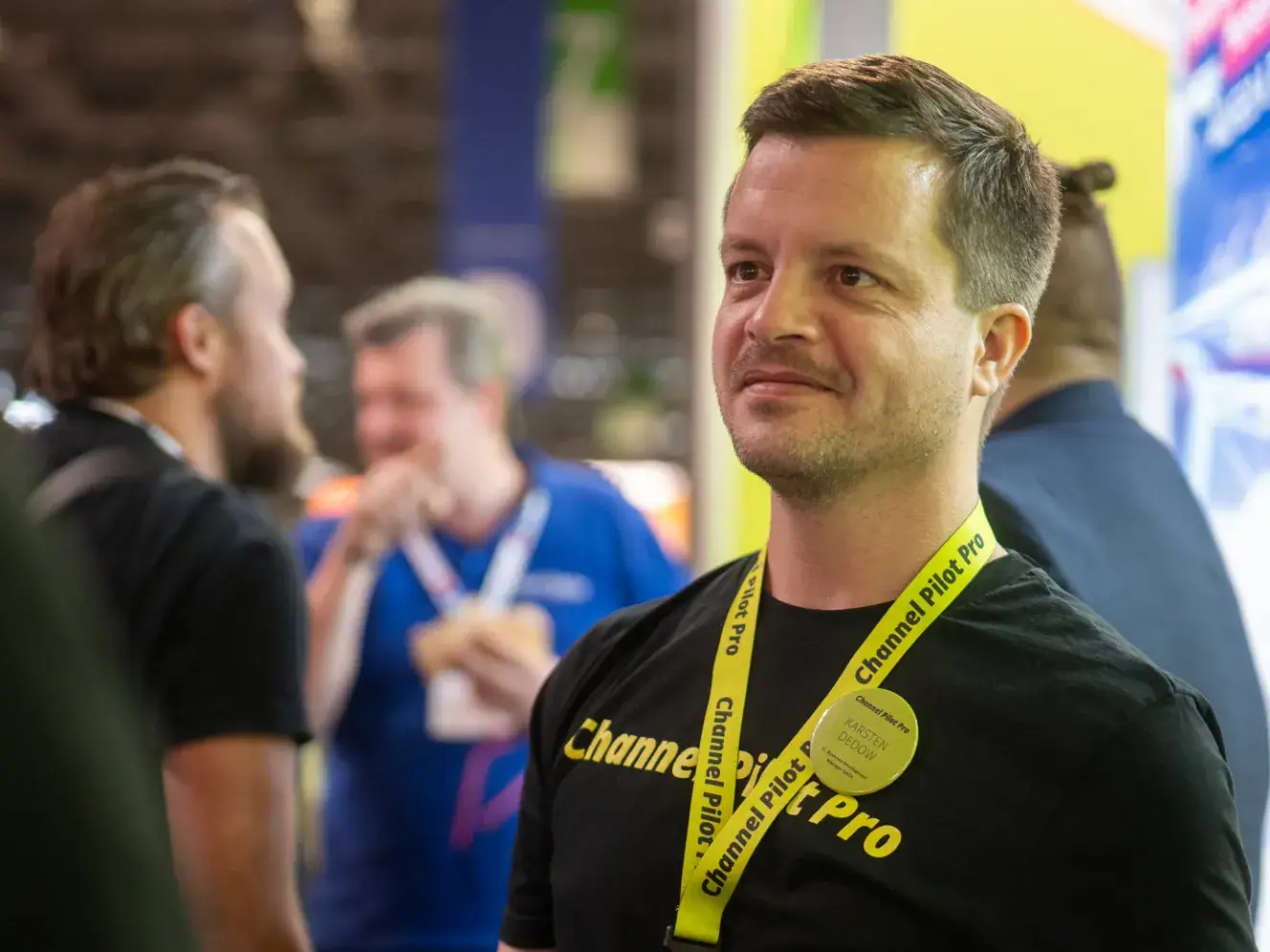 Mann mit Channel Pilot Pro T-Shirt und Lanyard bei einer Messe.