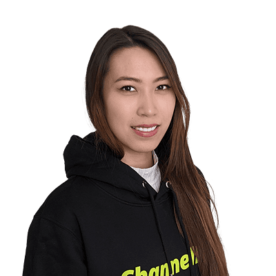 Junge asiatische Frau trägt schwarzen Hoodie mit Channel-Logo, lächelt freundlich.