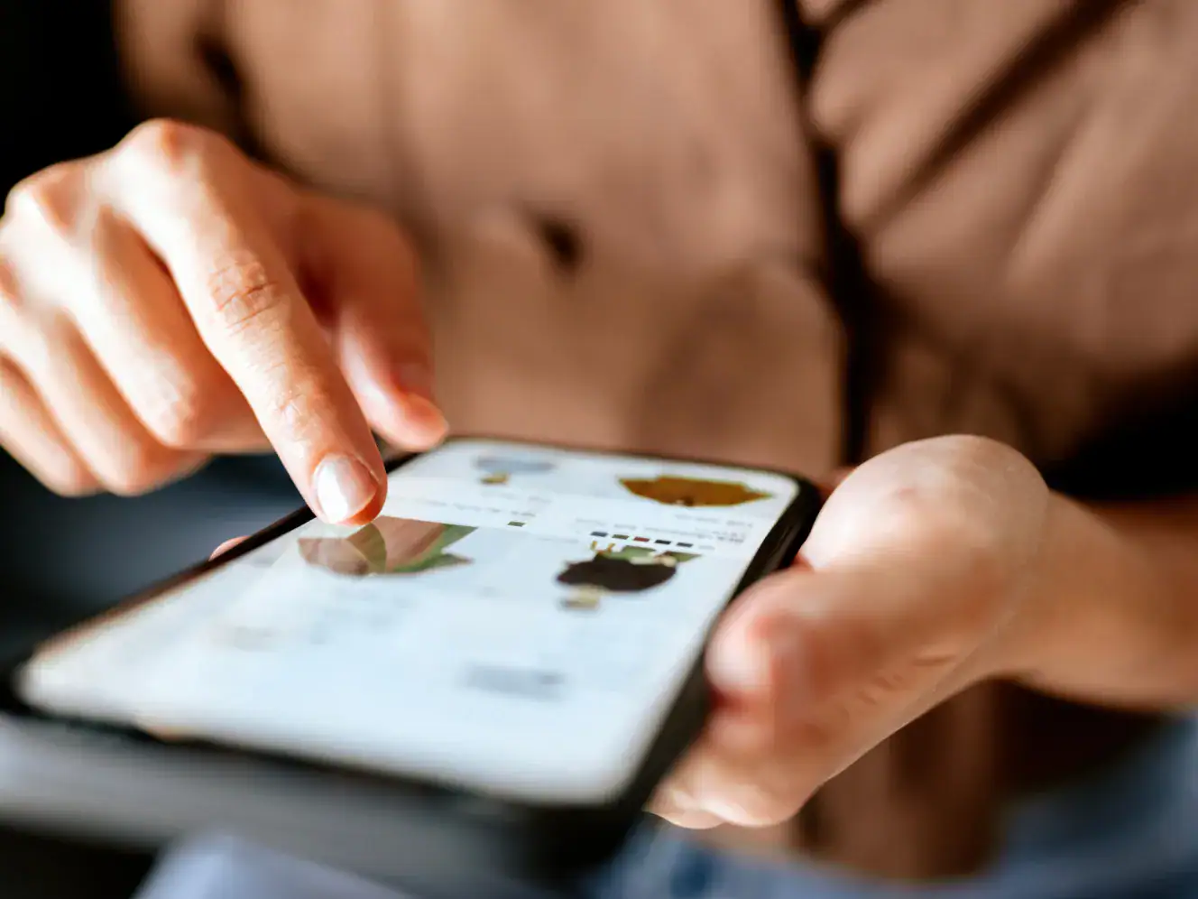 Mobiles Gerät mit einer Hand, das eine App oder Website nutzt, Nahaufnahme.