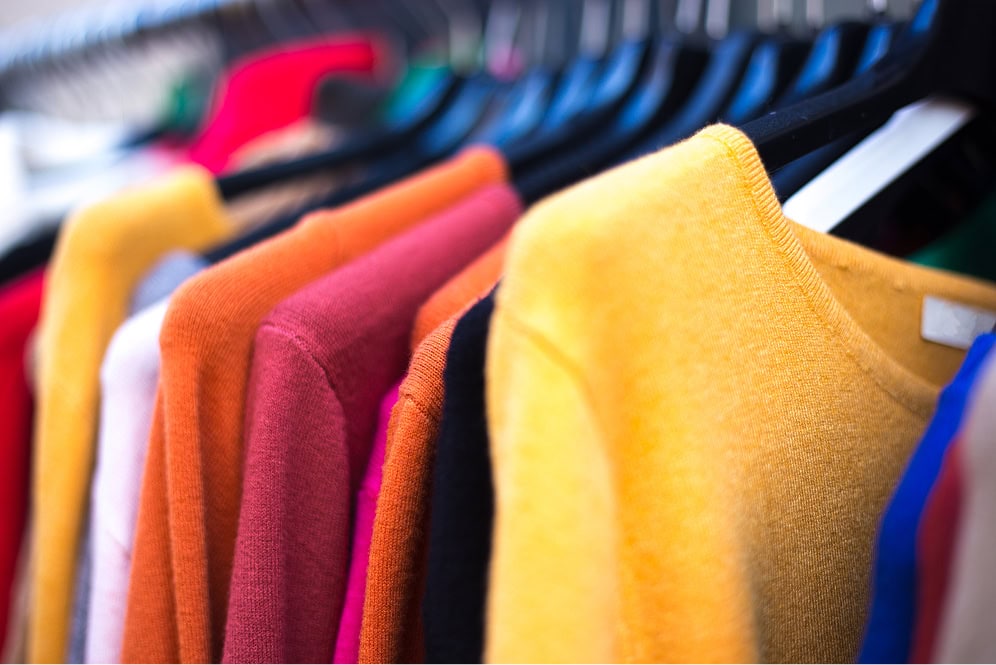 Bunte Sweatshirts hängen an einer Kleiderstange.
