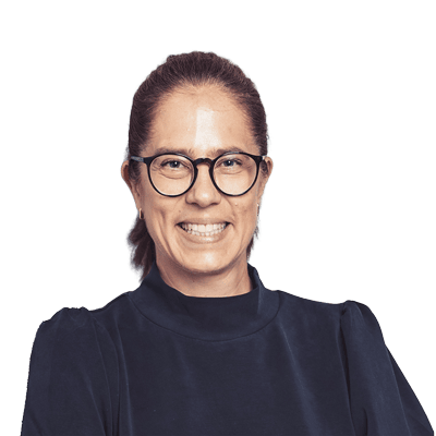 Frau mit Brille und dunklem Pullover lächelt freundlich in die Kamera.