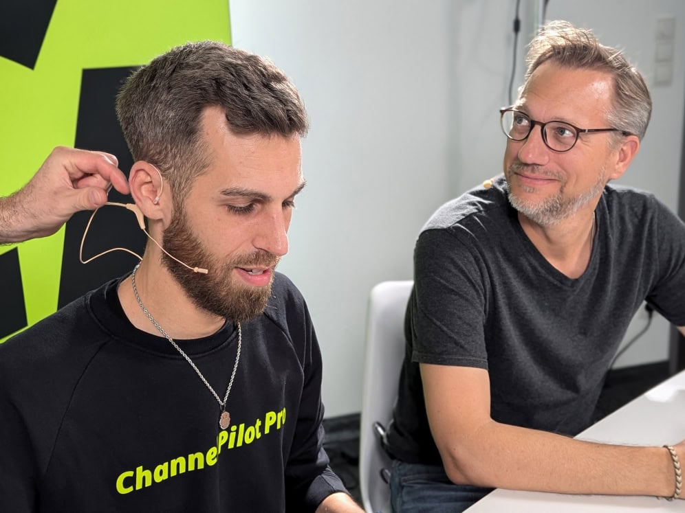 Hörgerätetest bei einem Mann mit einem Fachmann im Hintergrund.