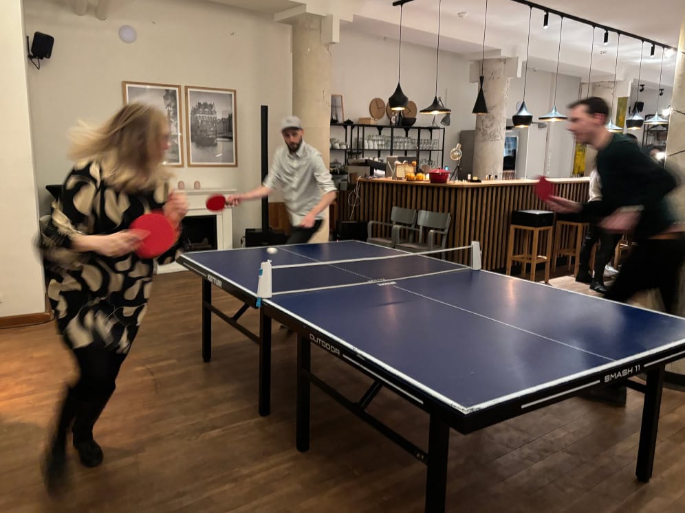 Tischtennis-Spiel im modernen Café mit Bar und gemütlicher Atmosphäre.